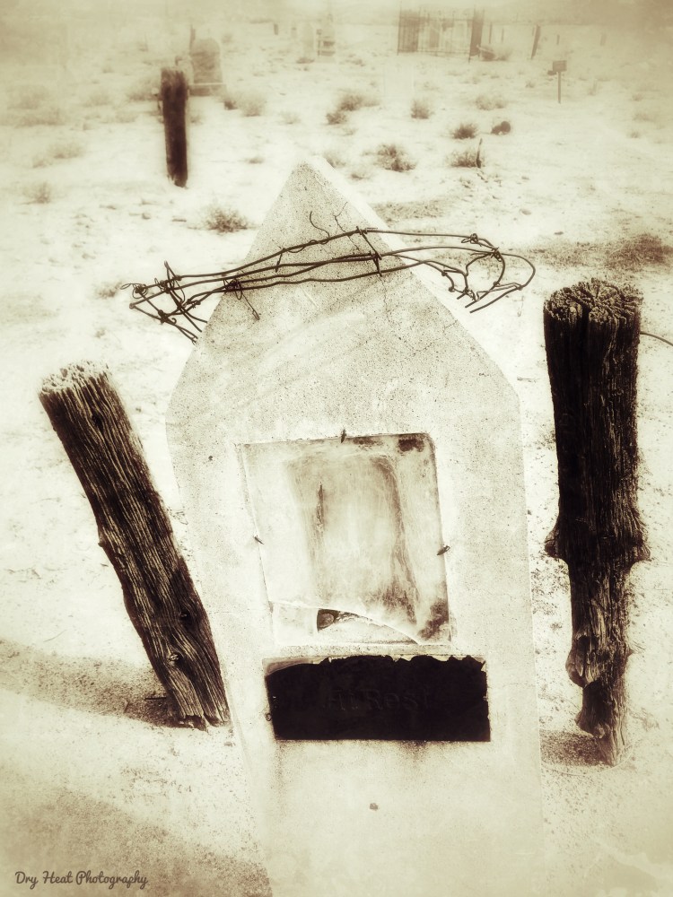 Concrete grave marker with a barbed wire crown at Our Lady of Guadalupe Cemetery in Peralta, New Mexico.