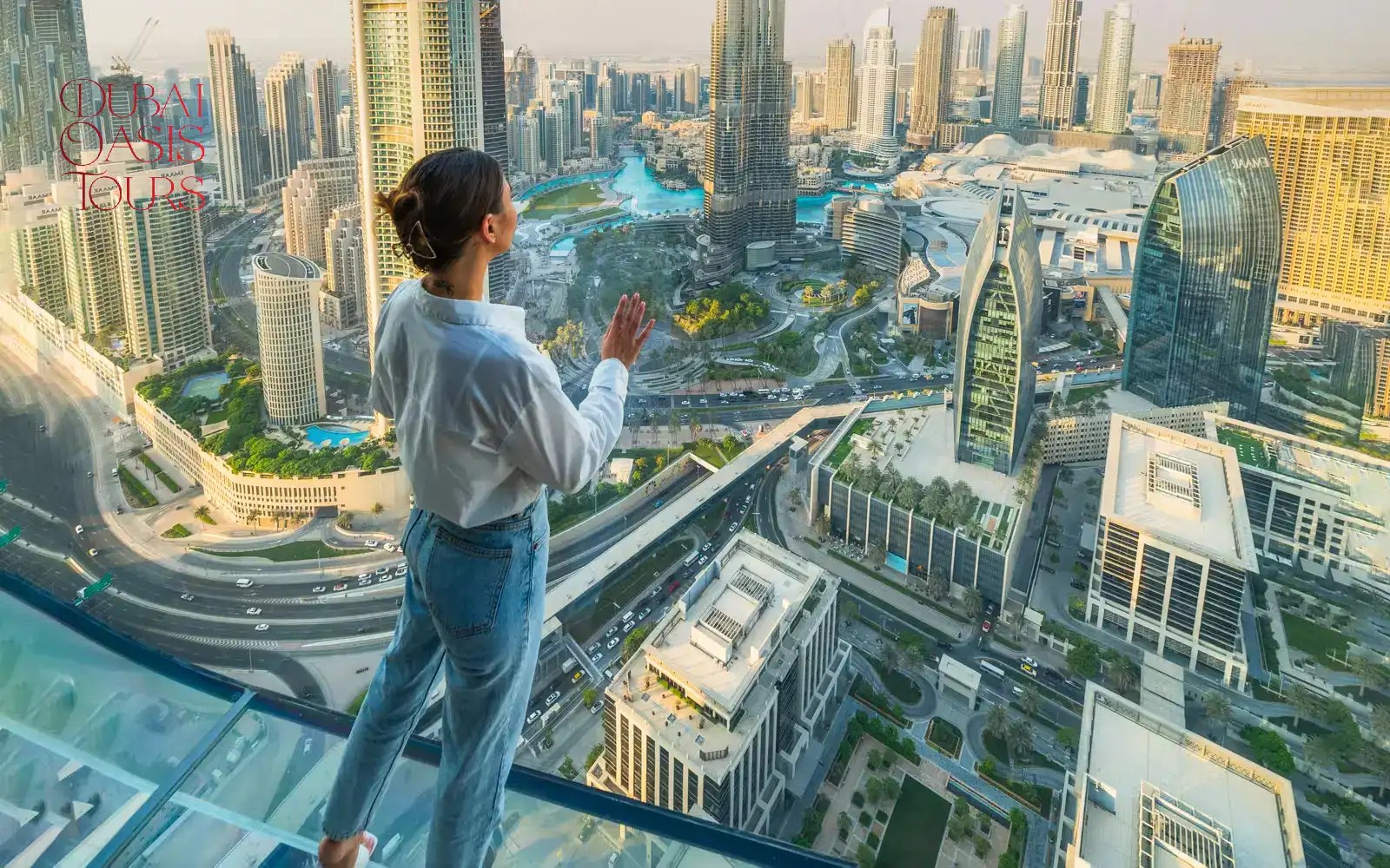 Visitors walking on the glass floor at Sky Views Observatory with Burj Khalifa in the background