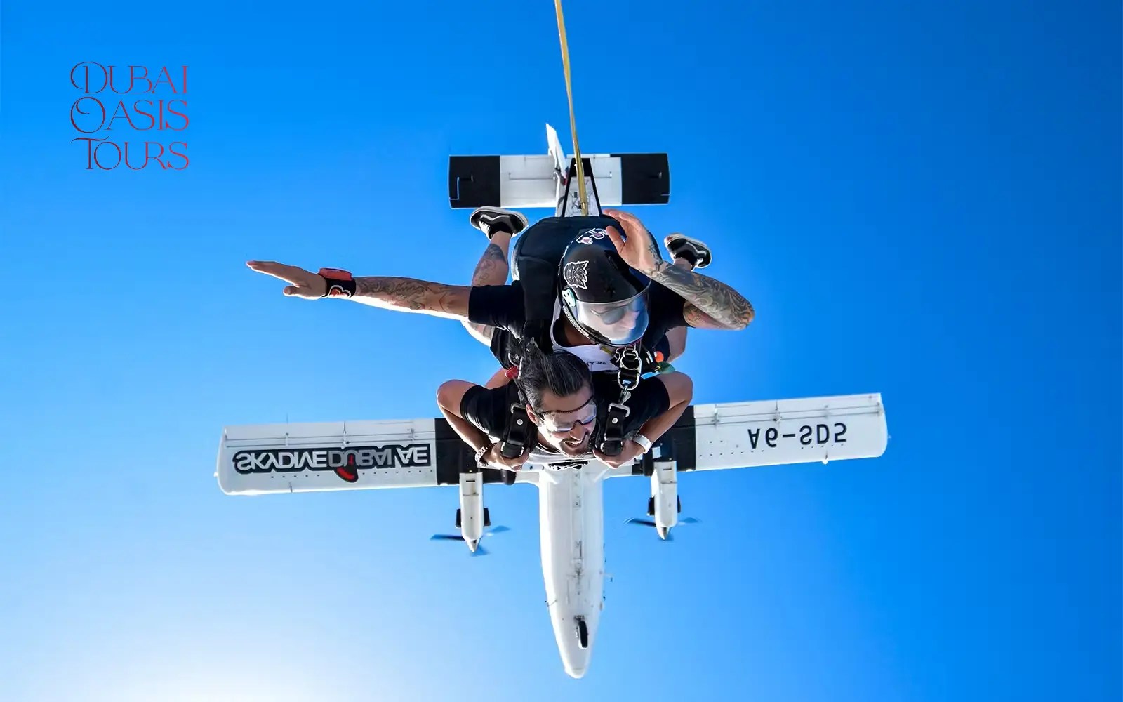 Skydiver soaring above golden sand dunes during desert skydive in Dubai
