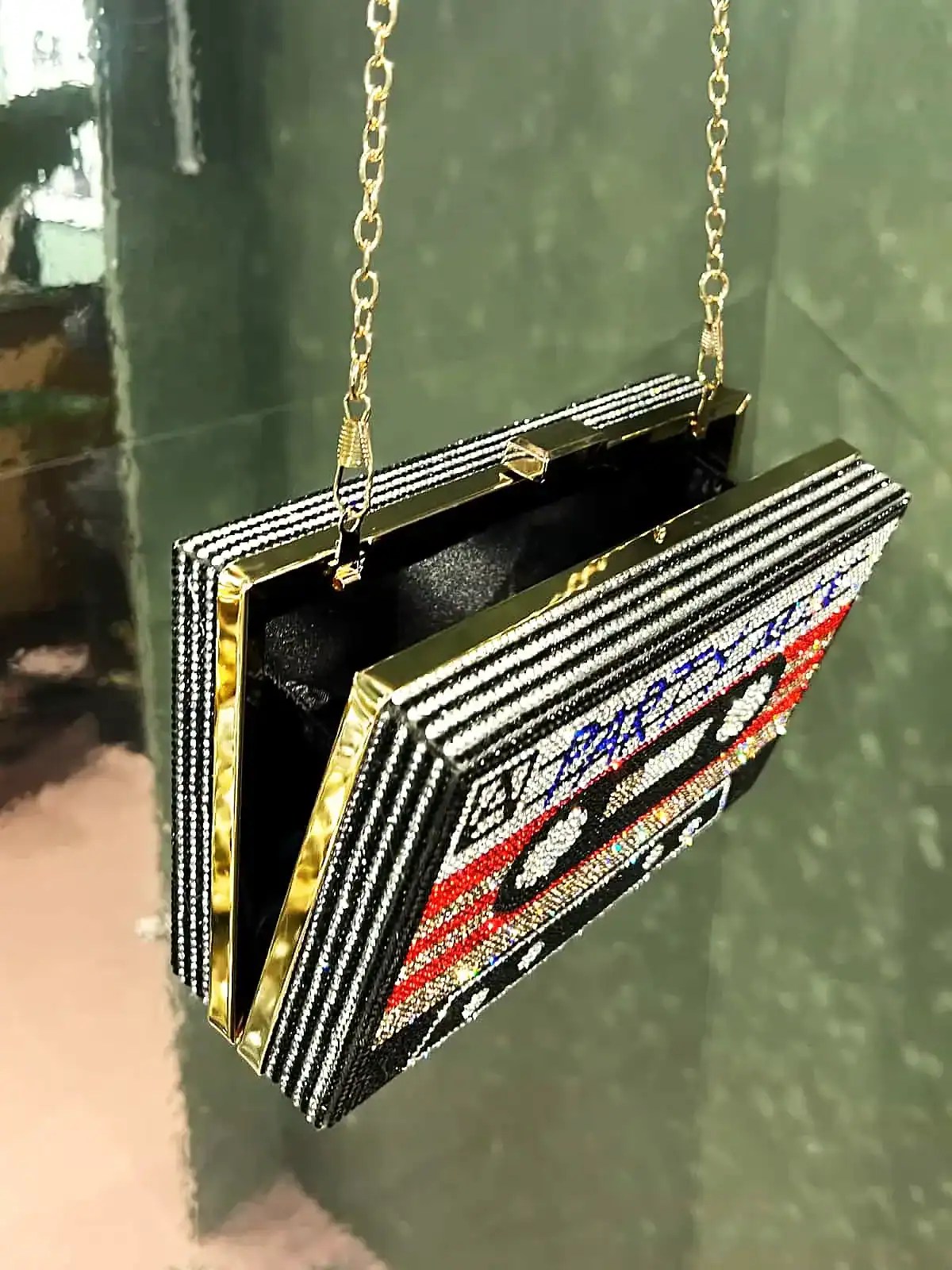 Elegant håndtaske med glitrende detaljer og kædehåndtag.
