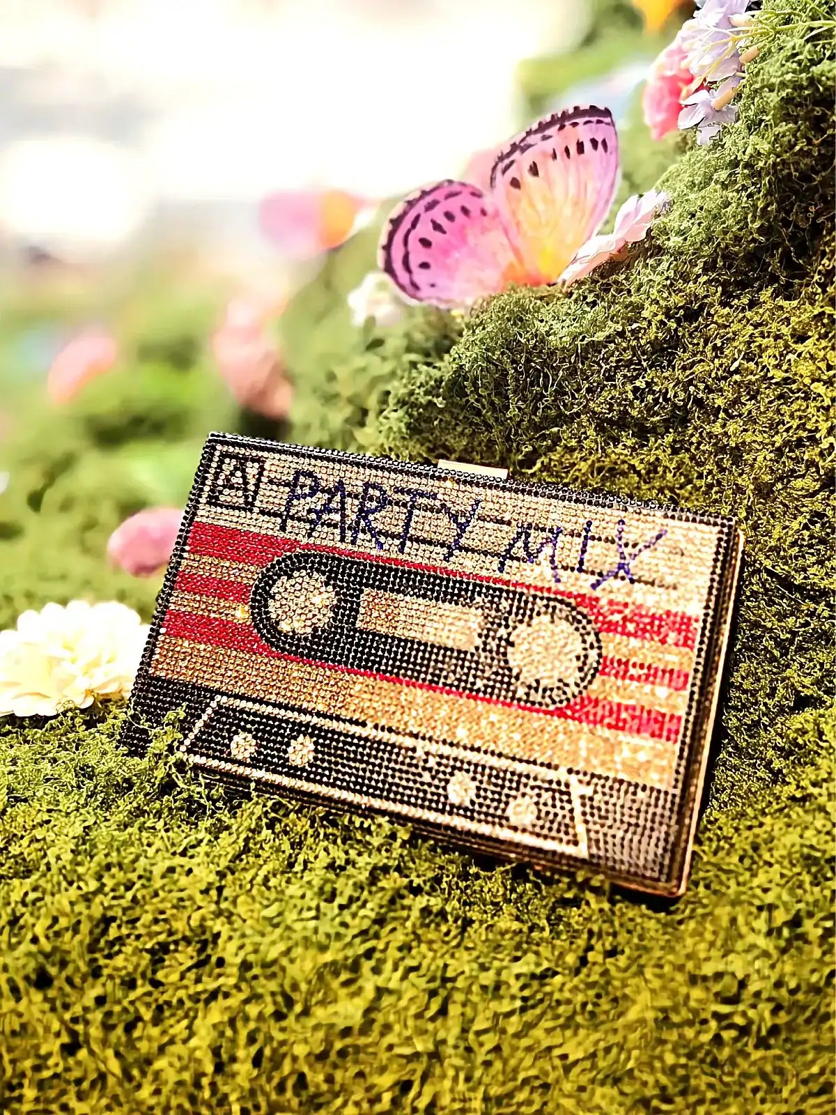 Fest clutch med farverigt design og tekst "Party mix".