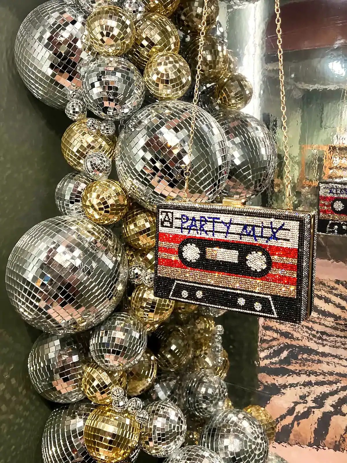 Festdekoration med glitrende disco-kugler i guld og sølv, samt en retro kassettebånds taske.