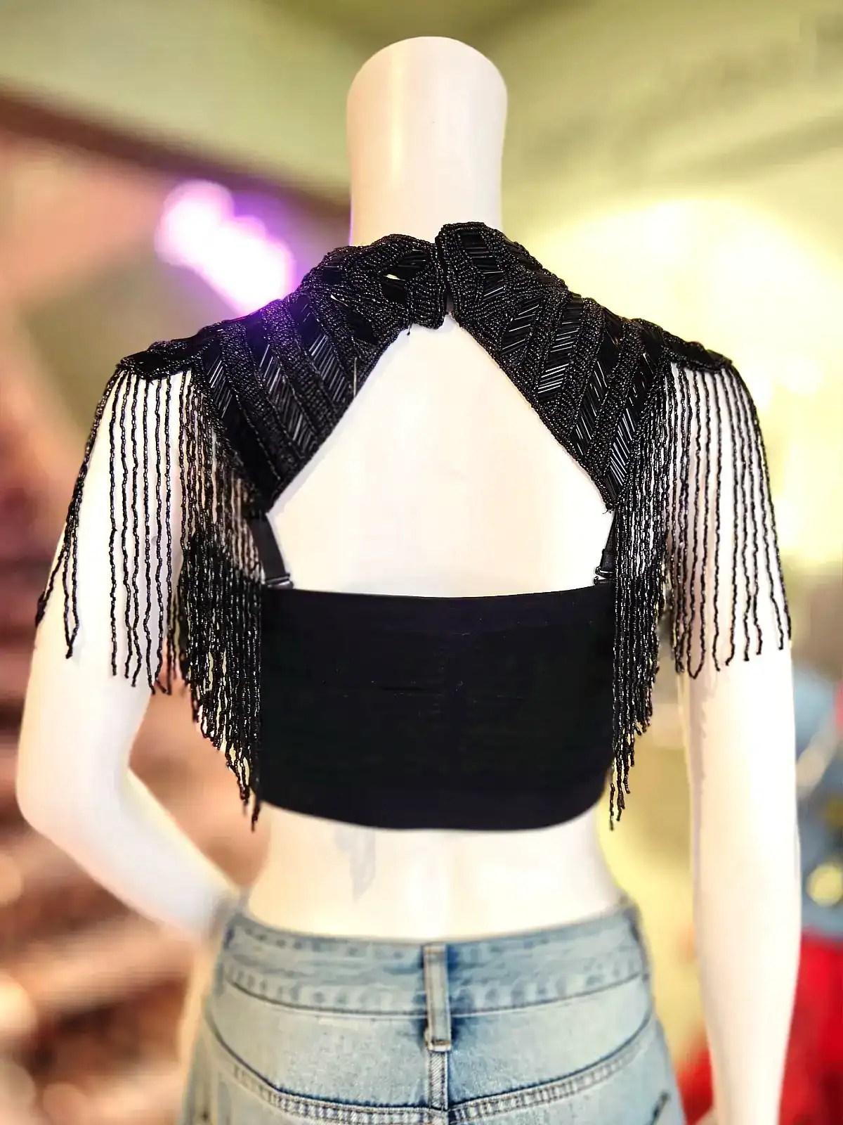 Sort capelet med frynser og perler, perfekt til fest og udklædning.