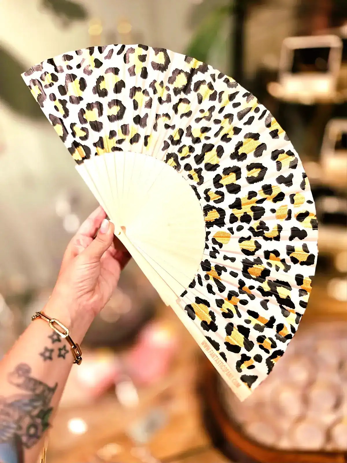 Håndventilator med leopardprint i gult, sort og hvidt.