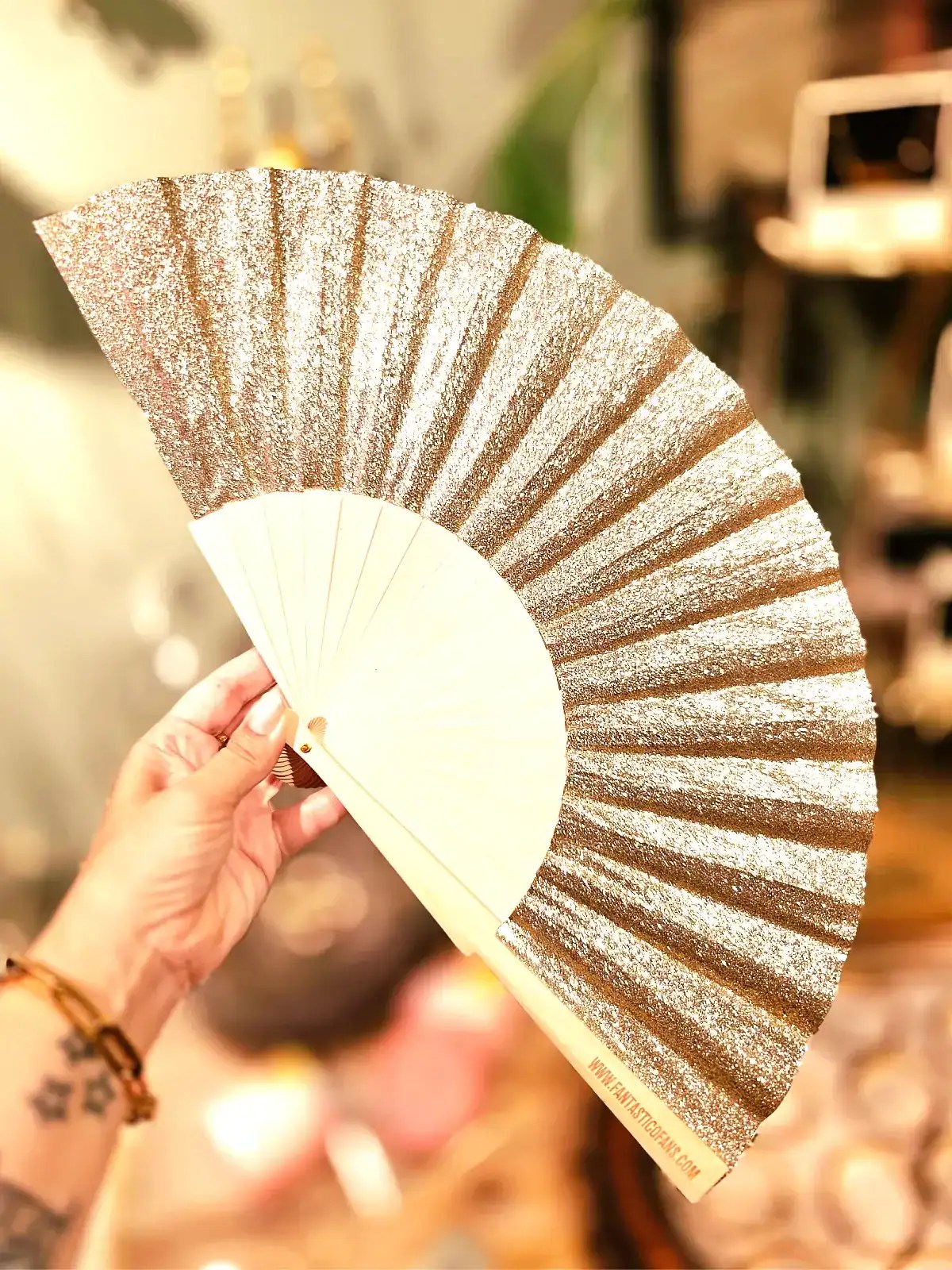 Håndholdt fan med glitter og elegant design til festlige lejligheder.