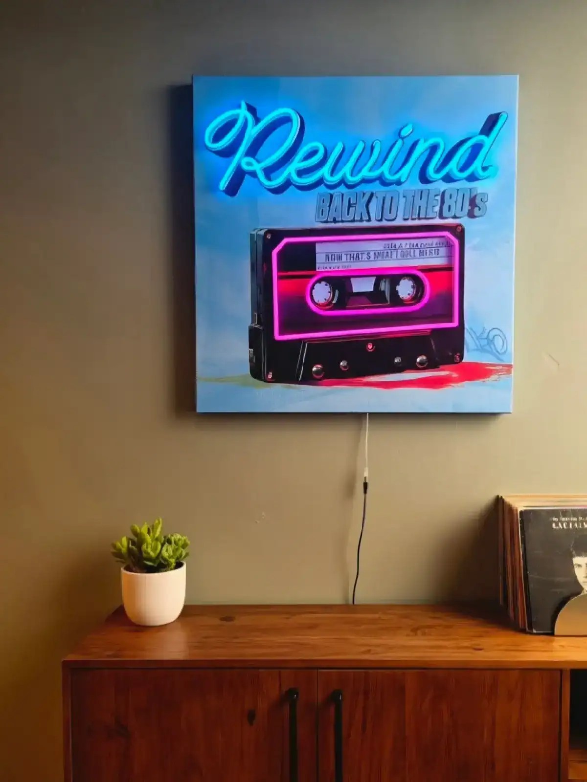 Vægspejl med neon-tekst 'Rewind' og kassettebånd, retro stil til vægdekoration.