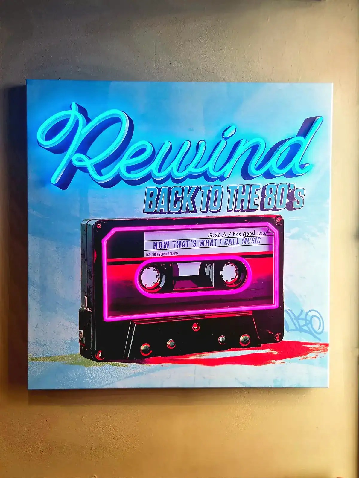 Neonlys med teksten 'Rewind Back to the 80's' og kassettebånd.