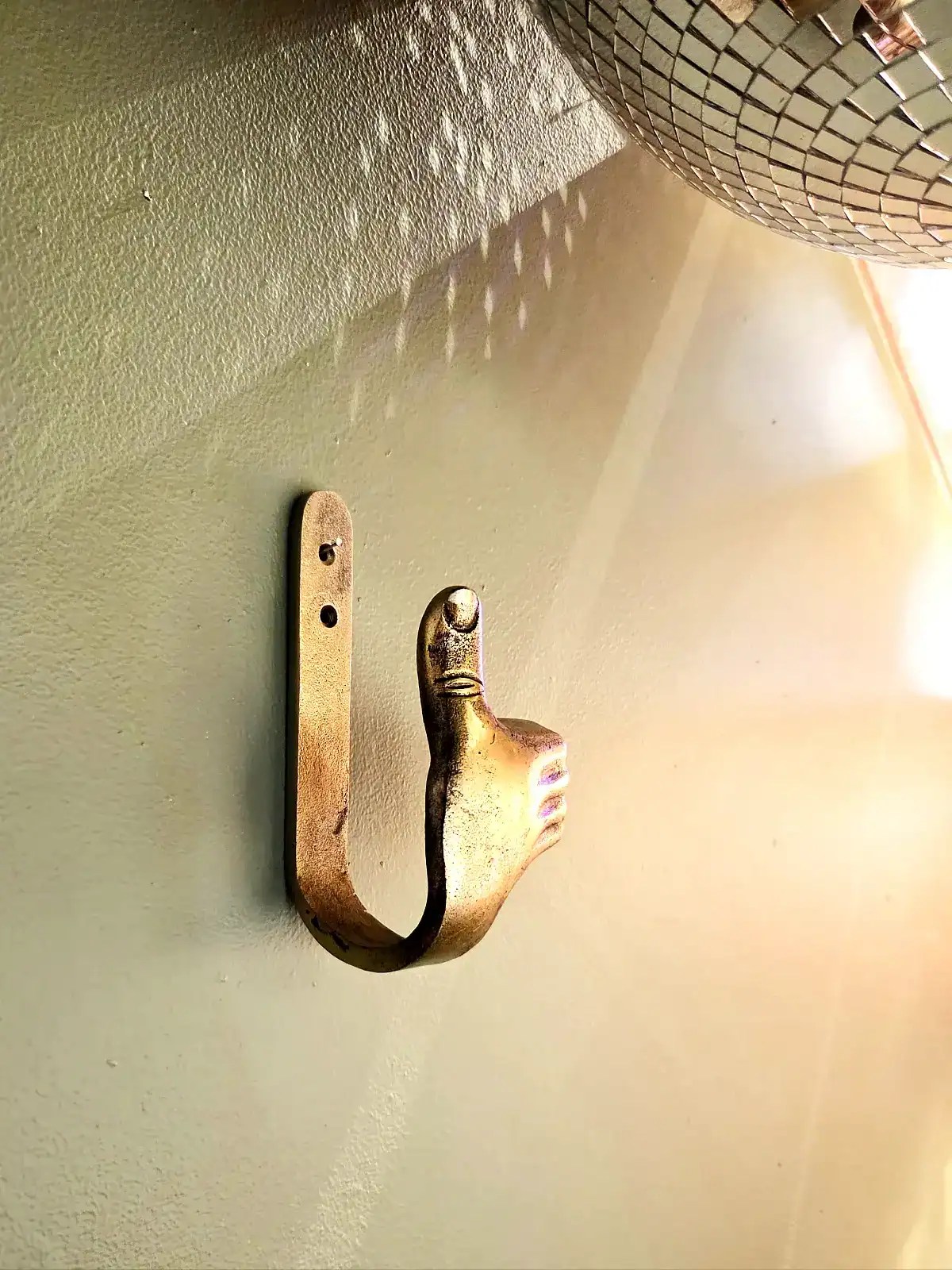 Elegant vægkrog med Thumbs Up design i sølvfinish.