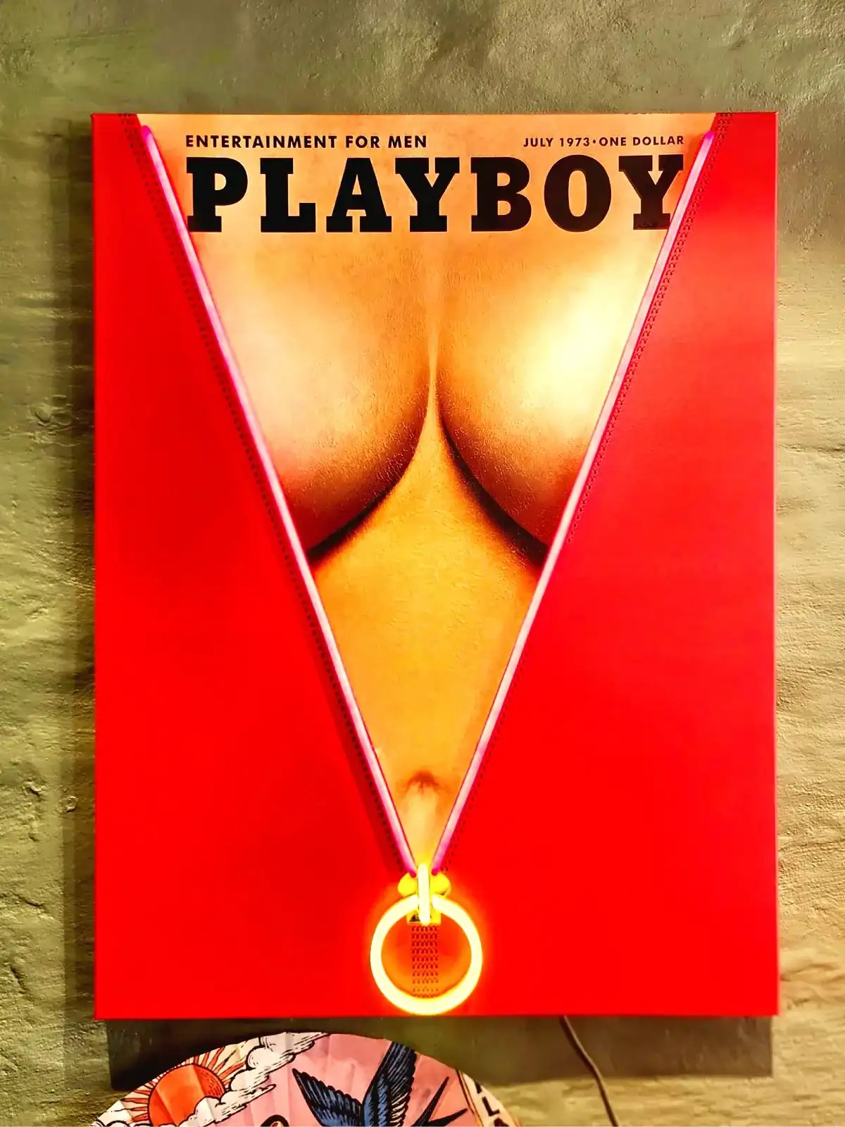 Vægspejl med Playboy-illustration og ringdetalje.