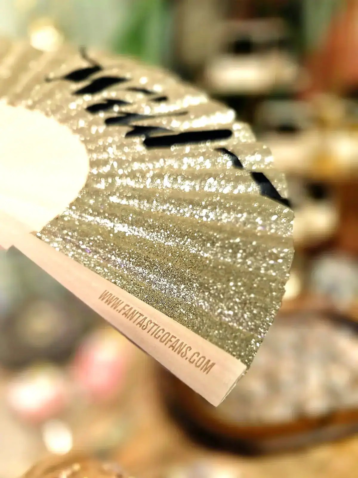 Elegant magisk vifte med glitter og sort design.