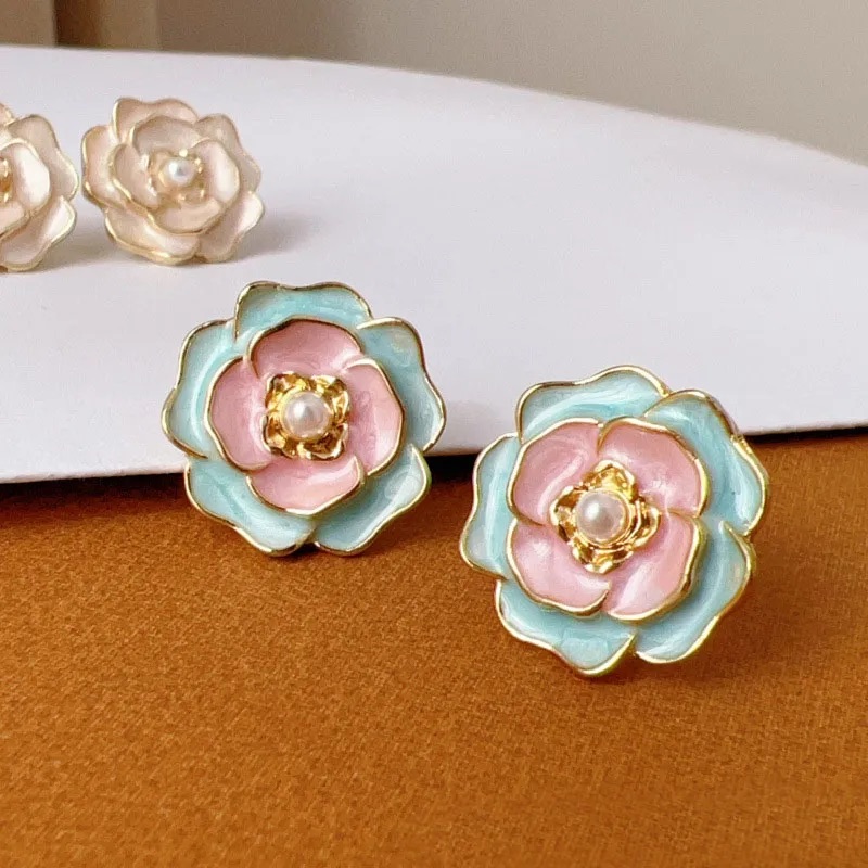 Aretes delicados en forma de rosa de colores pasteles