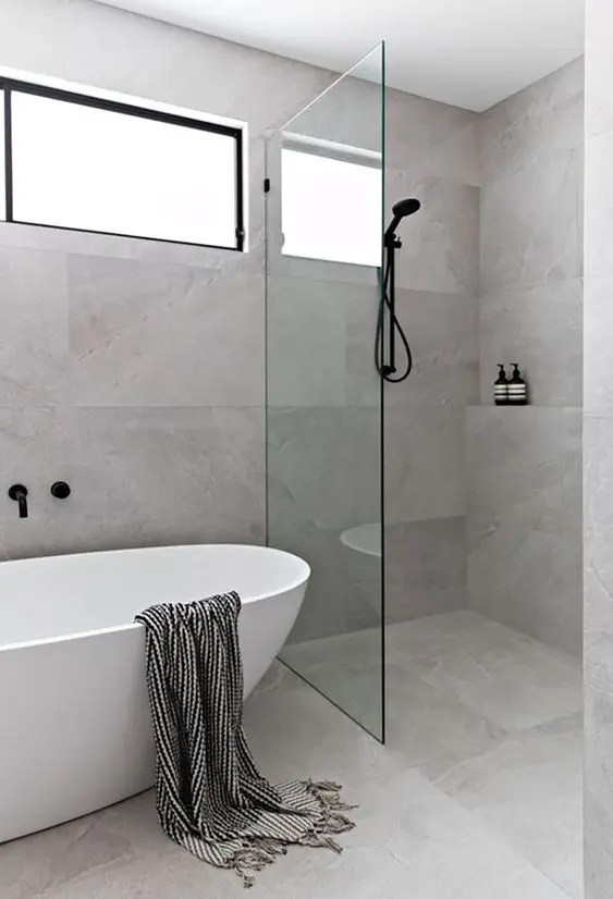 Bathroom tile flooring with large-format neutral tiles, creating a sleek and seamless modern design for a minimalist bathroom