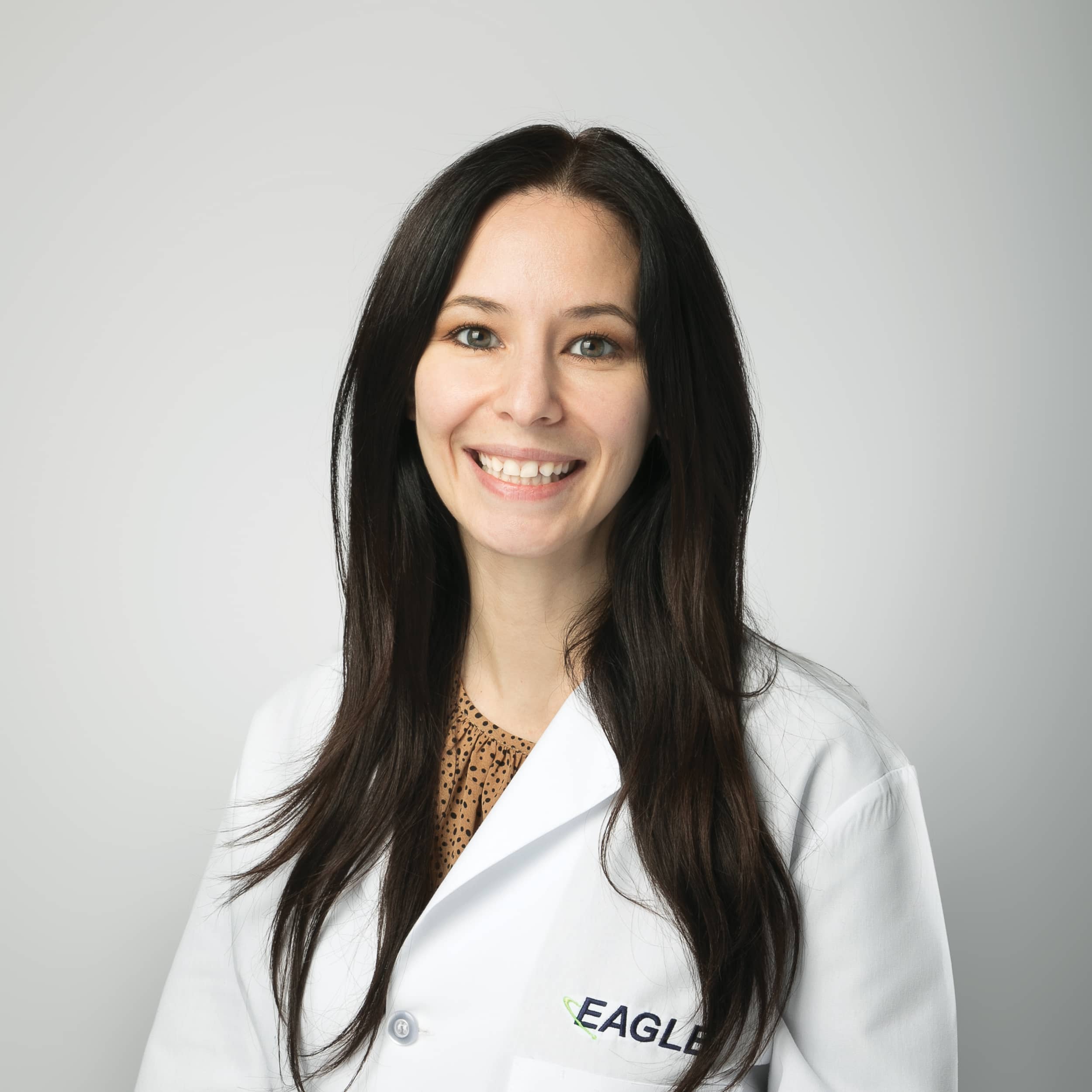 Jacqueline Esqueda Senior Businesses Development Specialist smiles while wearing an Eagle lab coat.