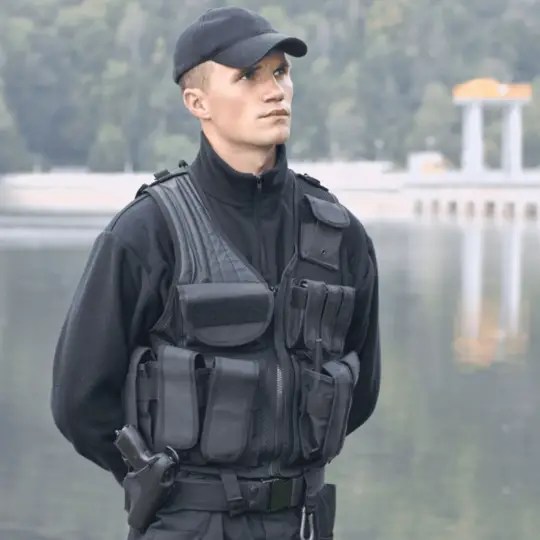 A man who is an armed security guard is standing.