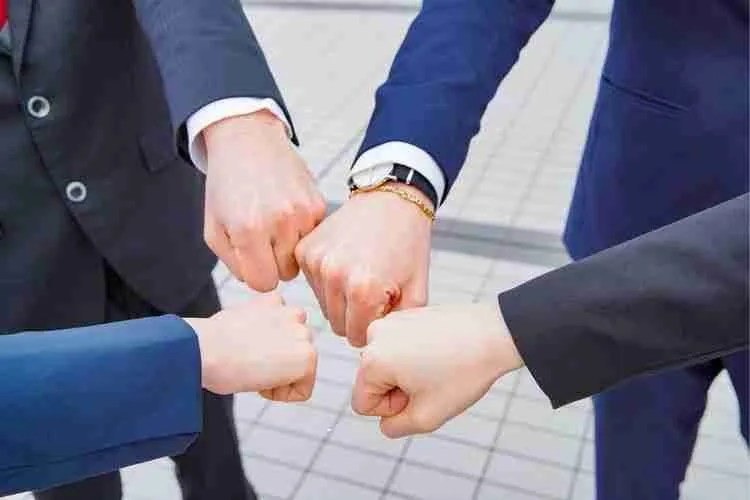 A group of professionals putting their fists together in teamwork.