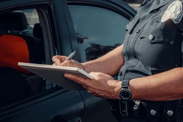 A licensed security officer writing down on her clipboard.
