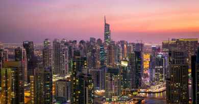 aerial view of city lit up at night (Real Estate)