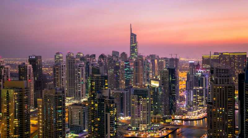 aerial view of city lit up at night (Real Estate)