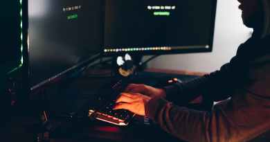 crop hacker silhouette typing on computer keyboard while hacking system