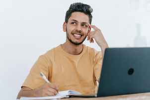 dreamy ethnic businessman thinking about project. (Be Positive)