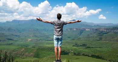 man wearing grey shirt standing on elevated surface