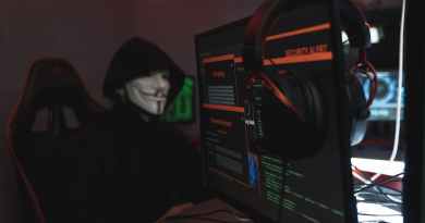 person in black hoodie hacking a computer system