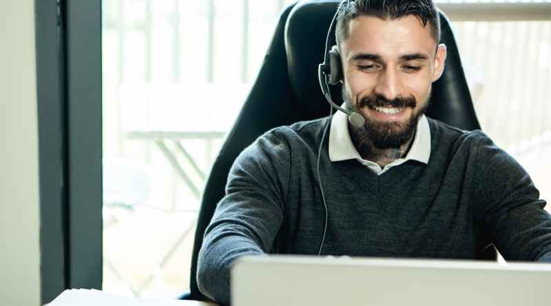 bearded man wearing headphones while working in the office