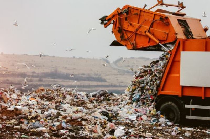 camion poubelle jetant des déchets dans une décharge