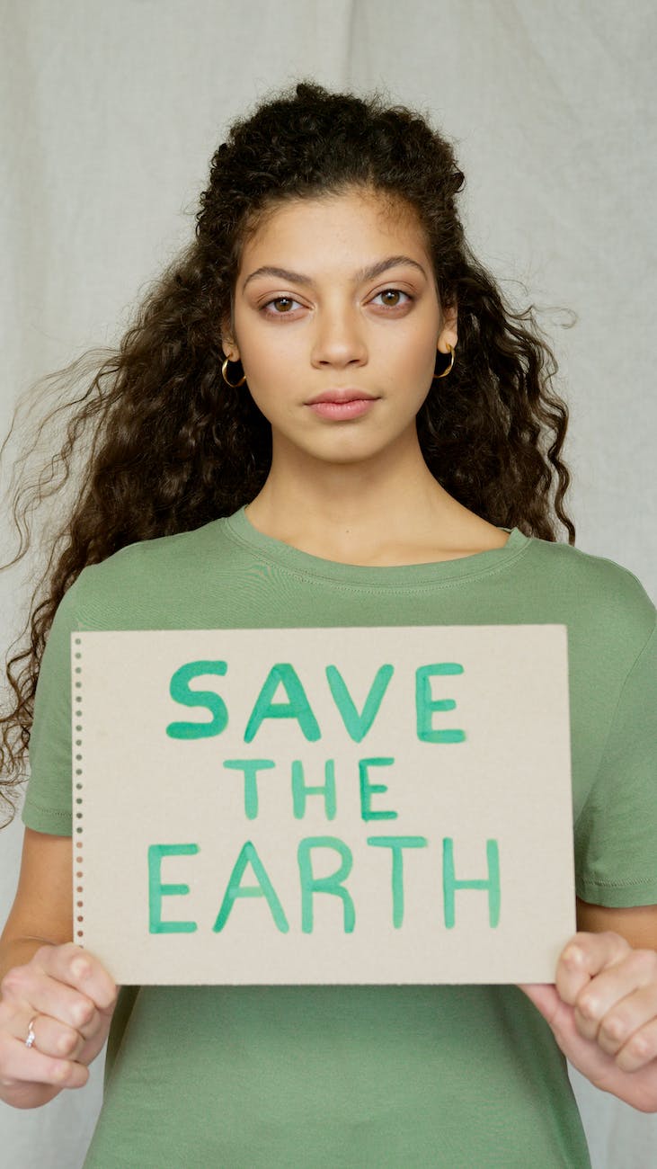 woman in green crew neck t shirt holding a sign