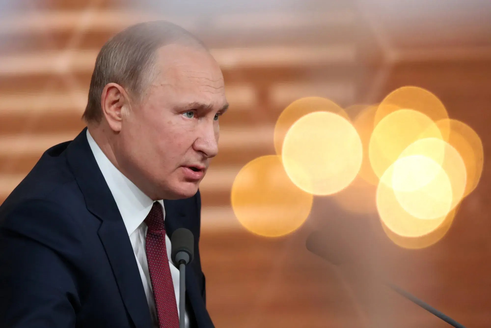 President Vladimir Putin sits sideways during a diplomatic meeting, discussing U.S.-Russia strategic weapons negotiations.