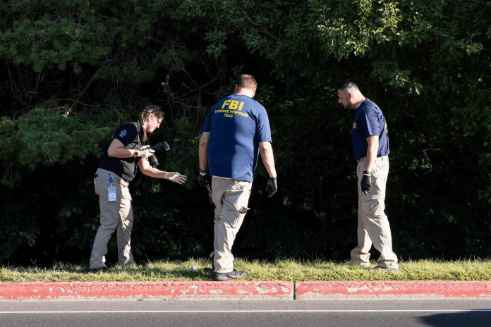 FBI Investigators At UVU Rooftop After Charlie Kirk Shooting FBI and campus police examine a UVU rooftop with cameras and evidence markers after the fatal shooting of Charlie Kirk in Orem, Utah.