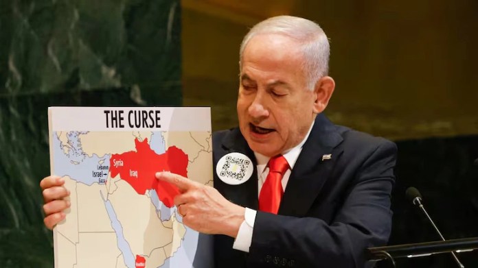 QR Pin And Prop During UN Speech Netanyahu wearing a QR code pin while referencing a graphic labeled “The Curse” during his UNGA speech.