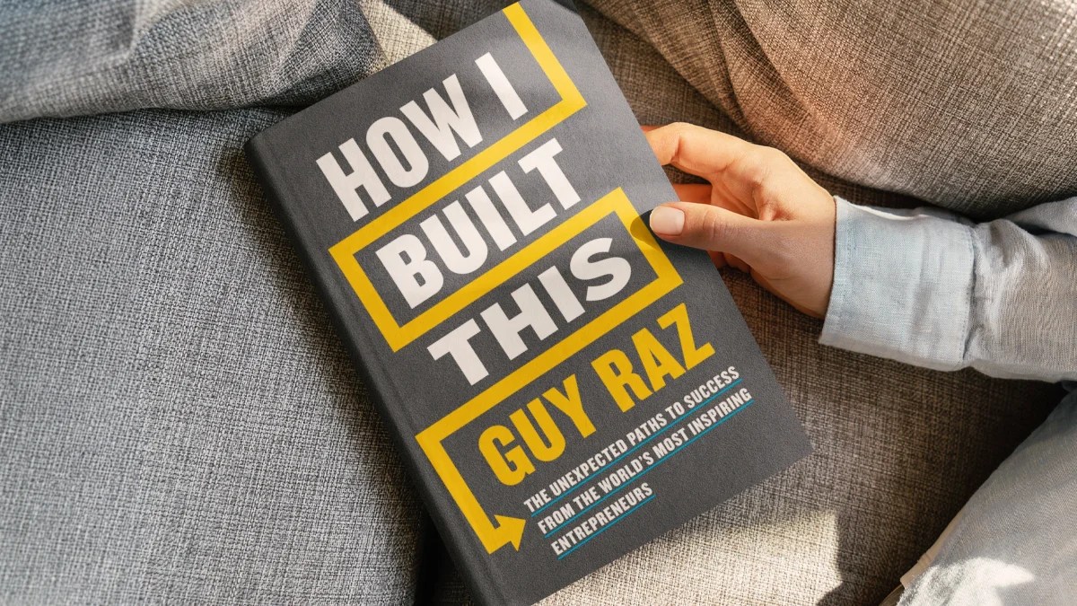 Someone holding the book How I Built This by Guy Raz.