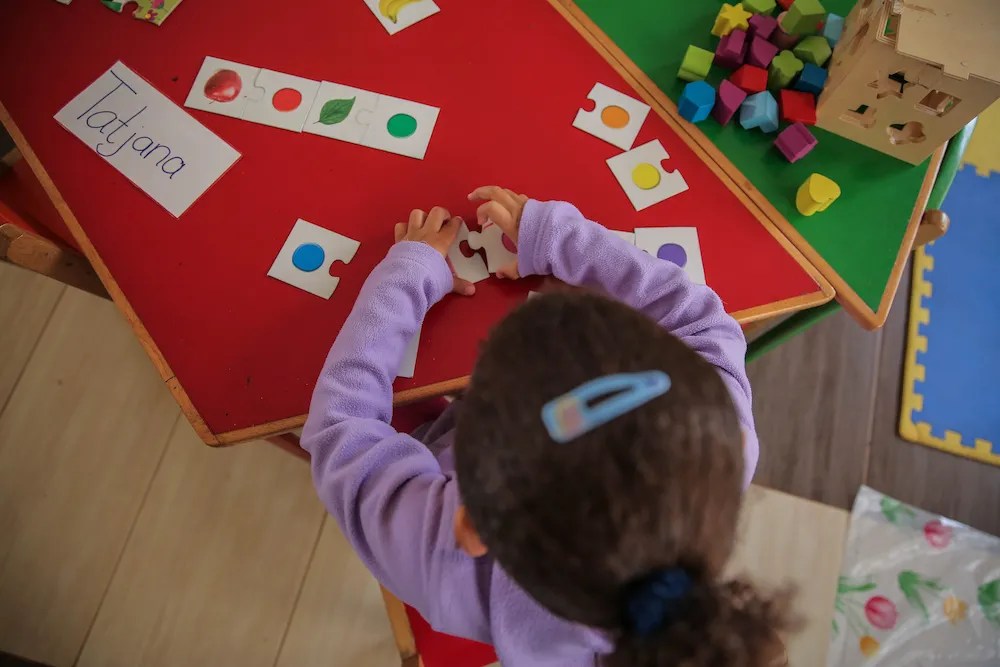 Nursery 1 - Child putting together puzzle pieces