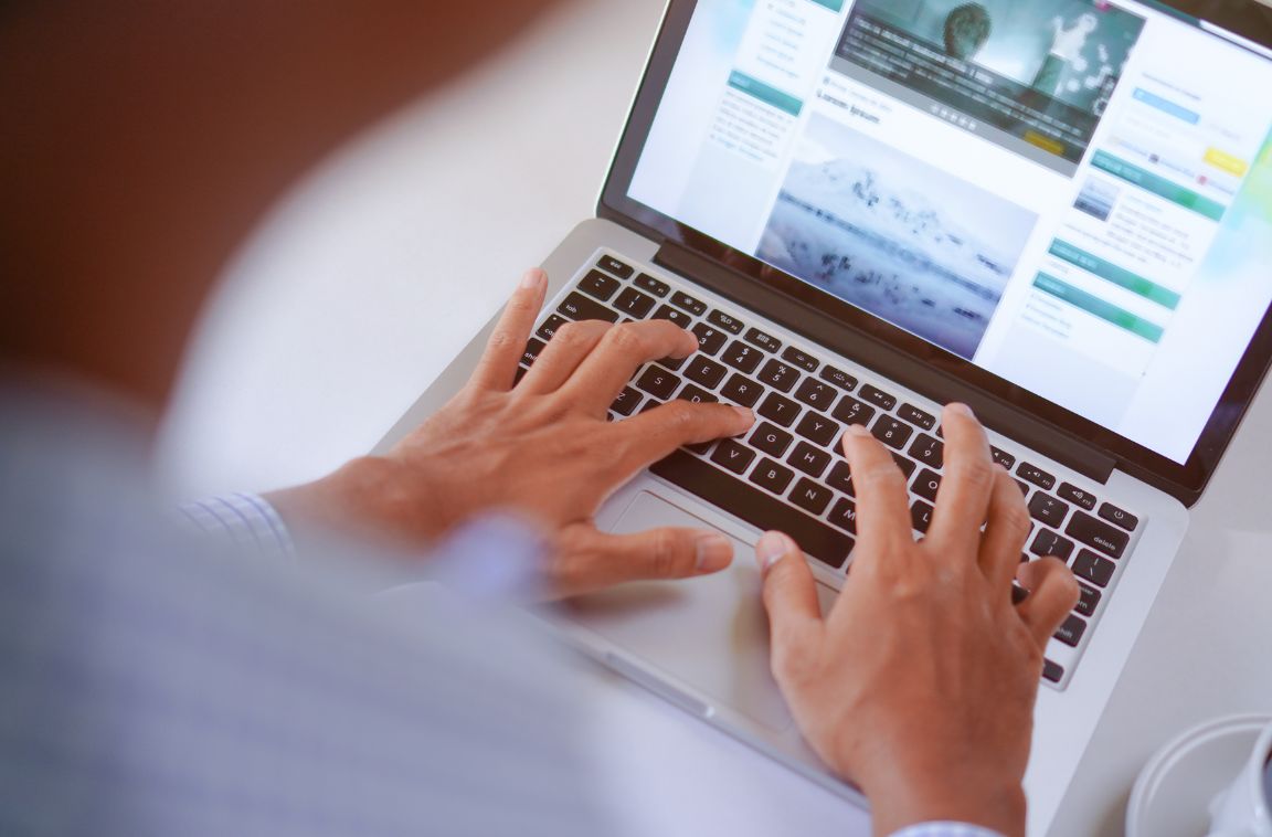 someone writing a blog post on a laptop