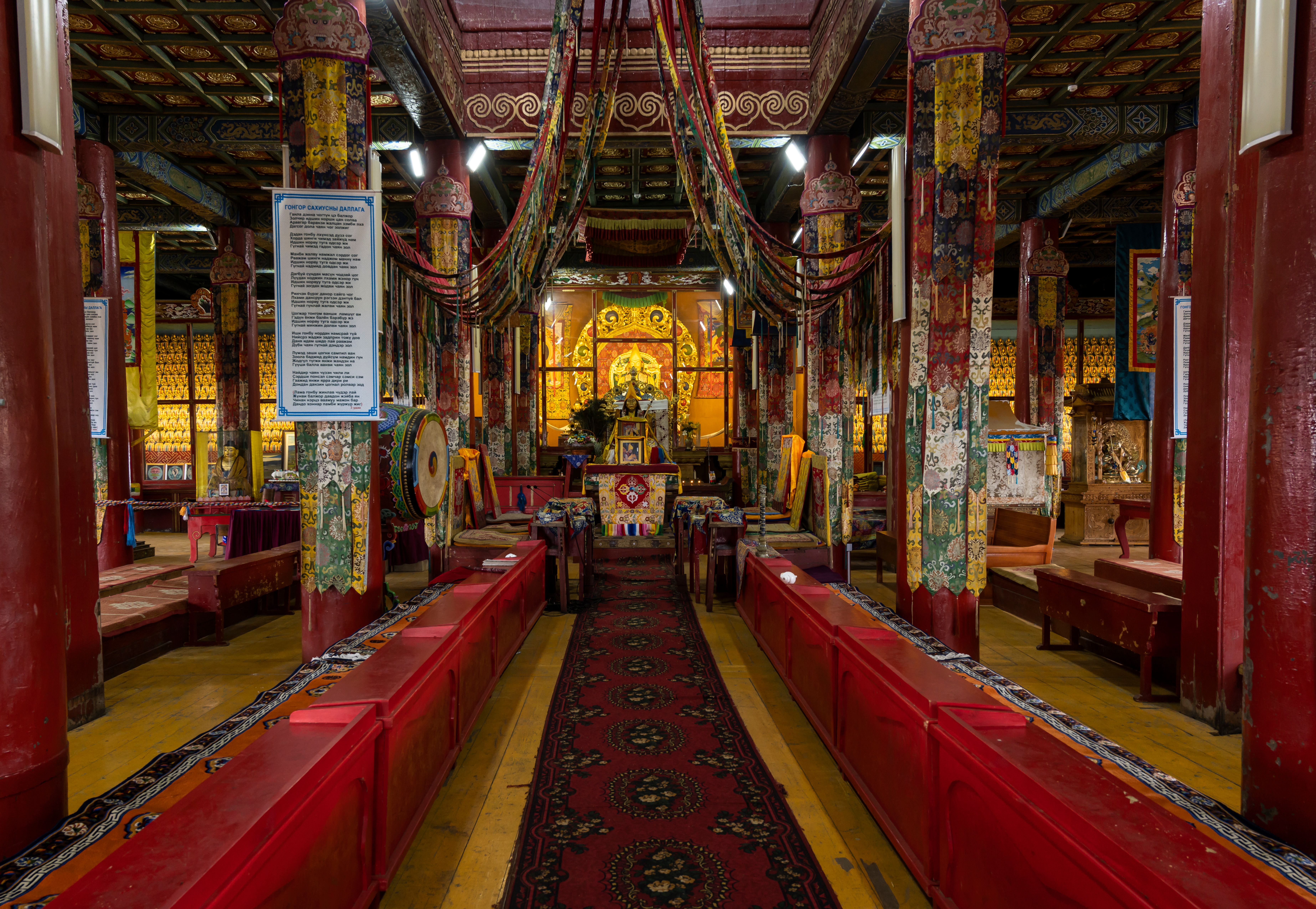 Red lacquered pillars line a carpeted aisle leading to a gilded shrine inside the temple at Amarbayasgalant Monastery, Mongolia