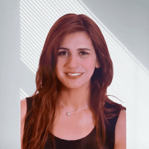A woman with long brown hair and a necklace, smiling against a light background with diagonal lines.