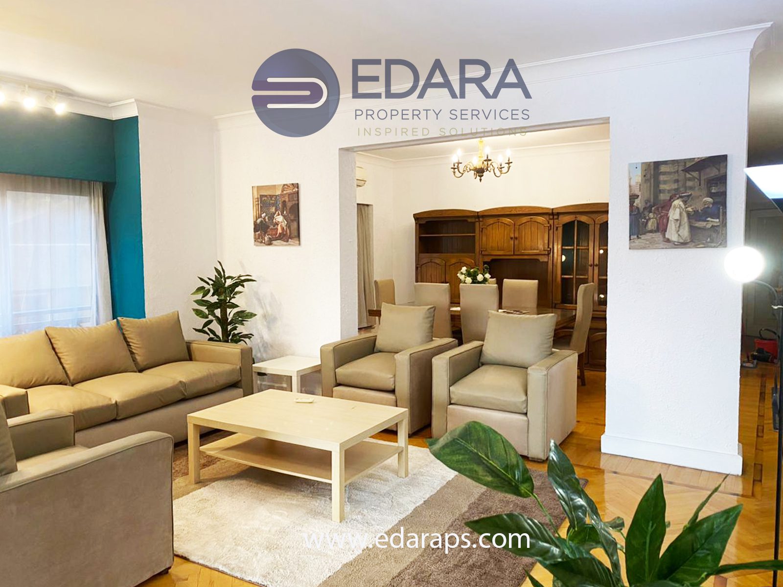 Living room with beige sofas, a coffee table, and decorative paintings on the walls.