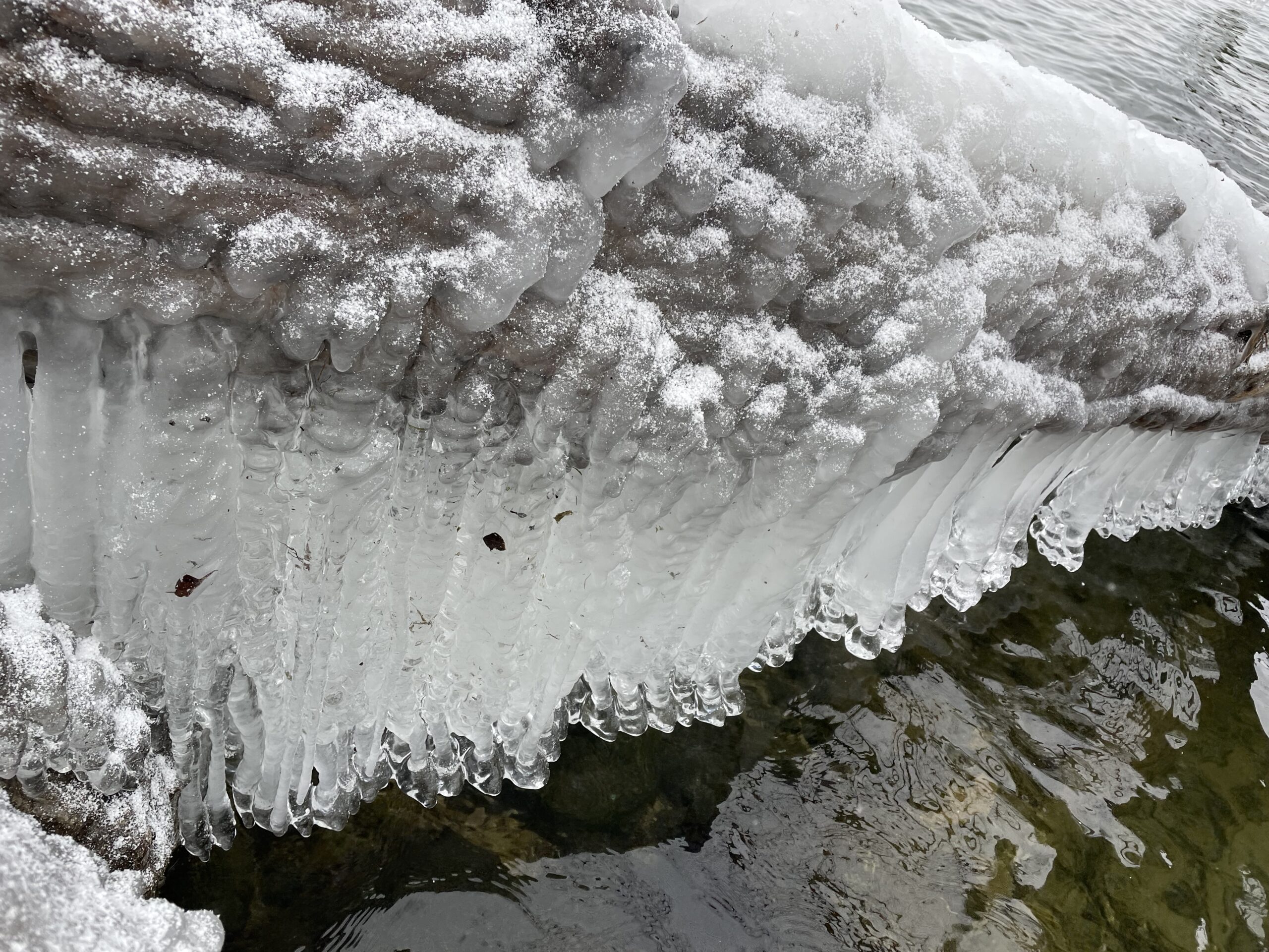 A tall block of ice, some cloudy, some relatively clear.