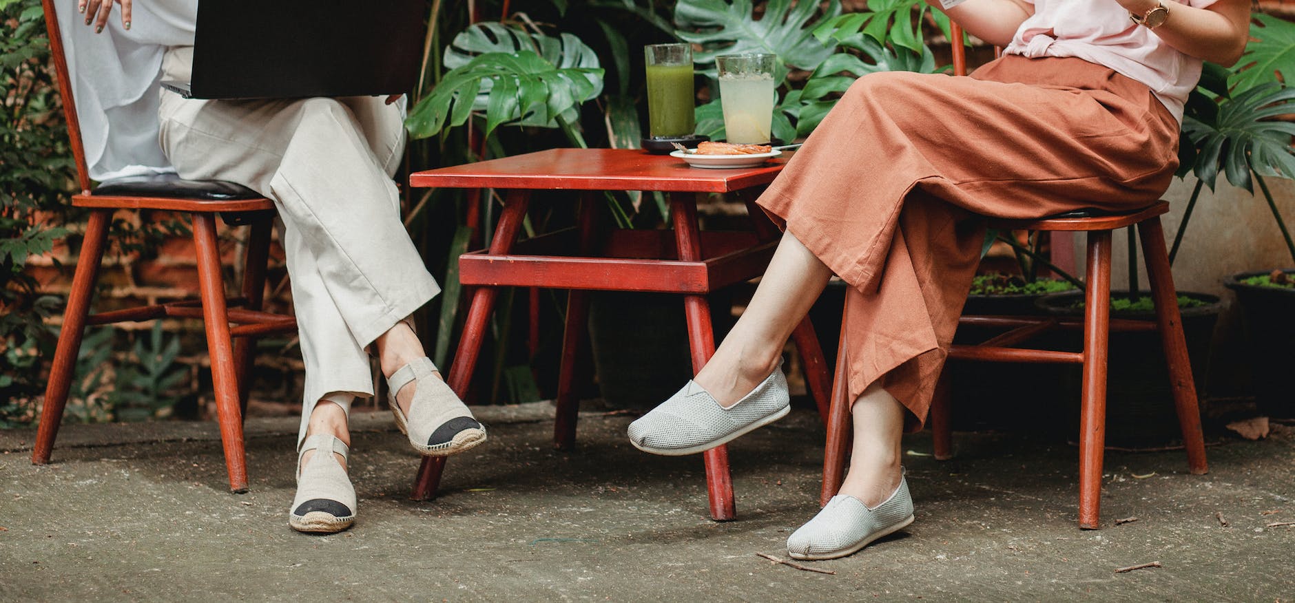 crop stylish women on terrace of cafe