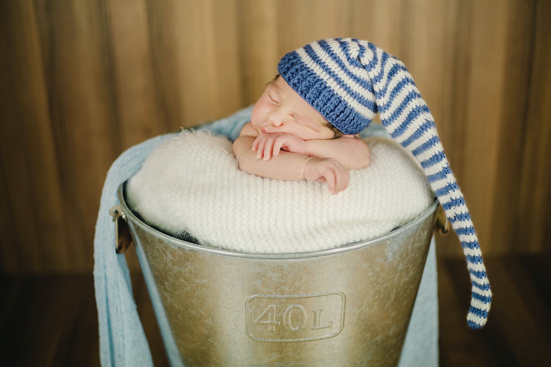 adorable baby in nightcap sleeping in bucket