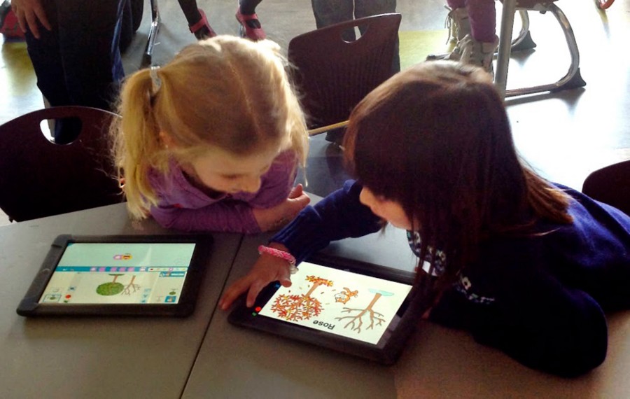 Young child using Scratch Jr on a tablet, dragging colorful picture-based coding blocks to make characters move and interact.