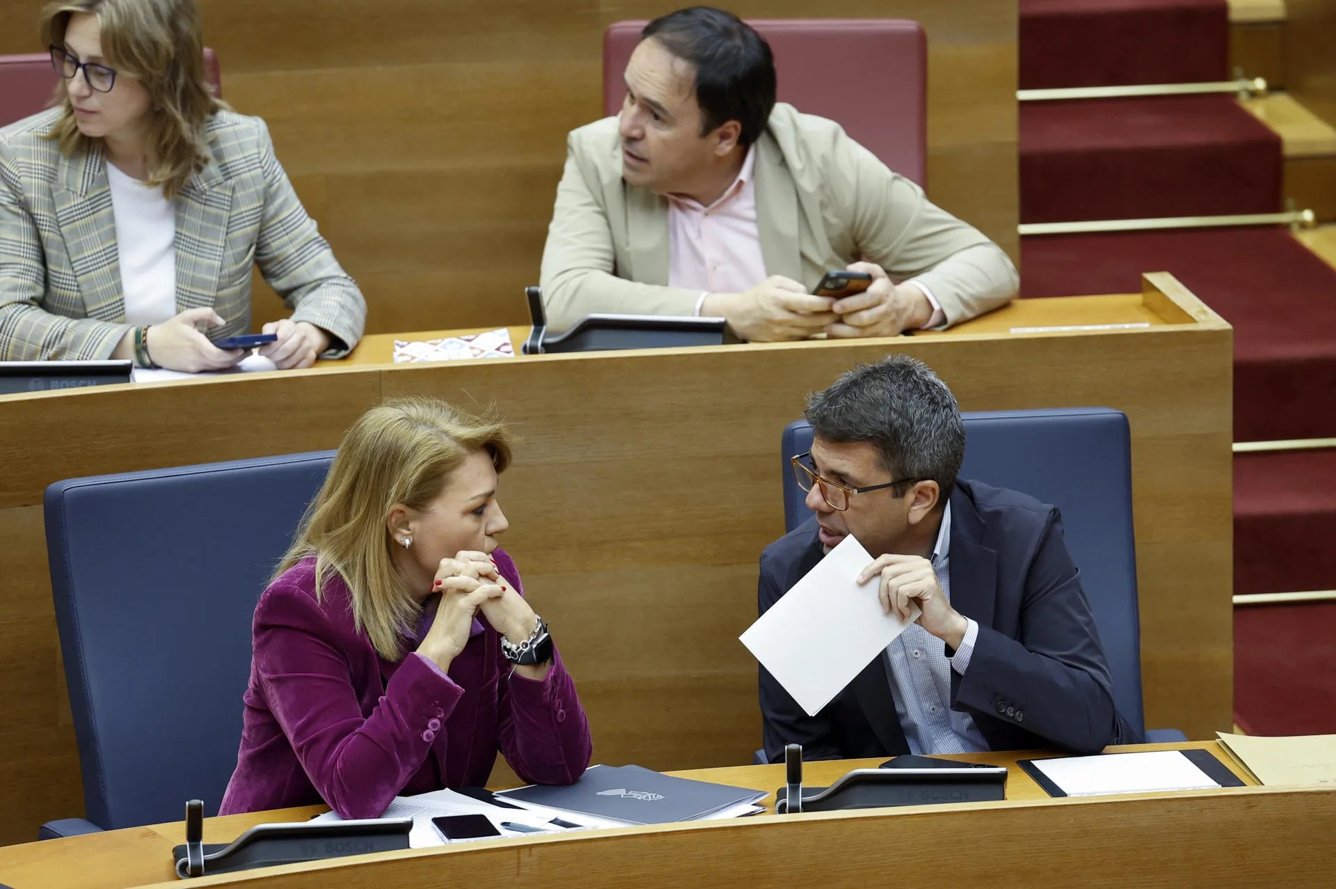 El president de la Genralitat, Carlos Mazón, conversa con la vicepresidenta primera, Susana Camarero, durante un pleno de Les Corts Valencianes. EFE/Ana Escobar
