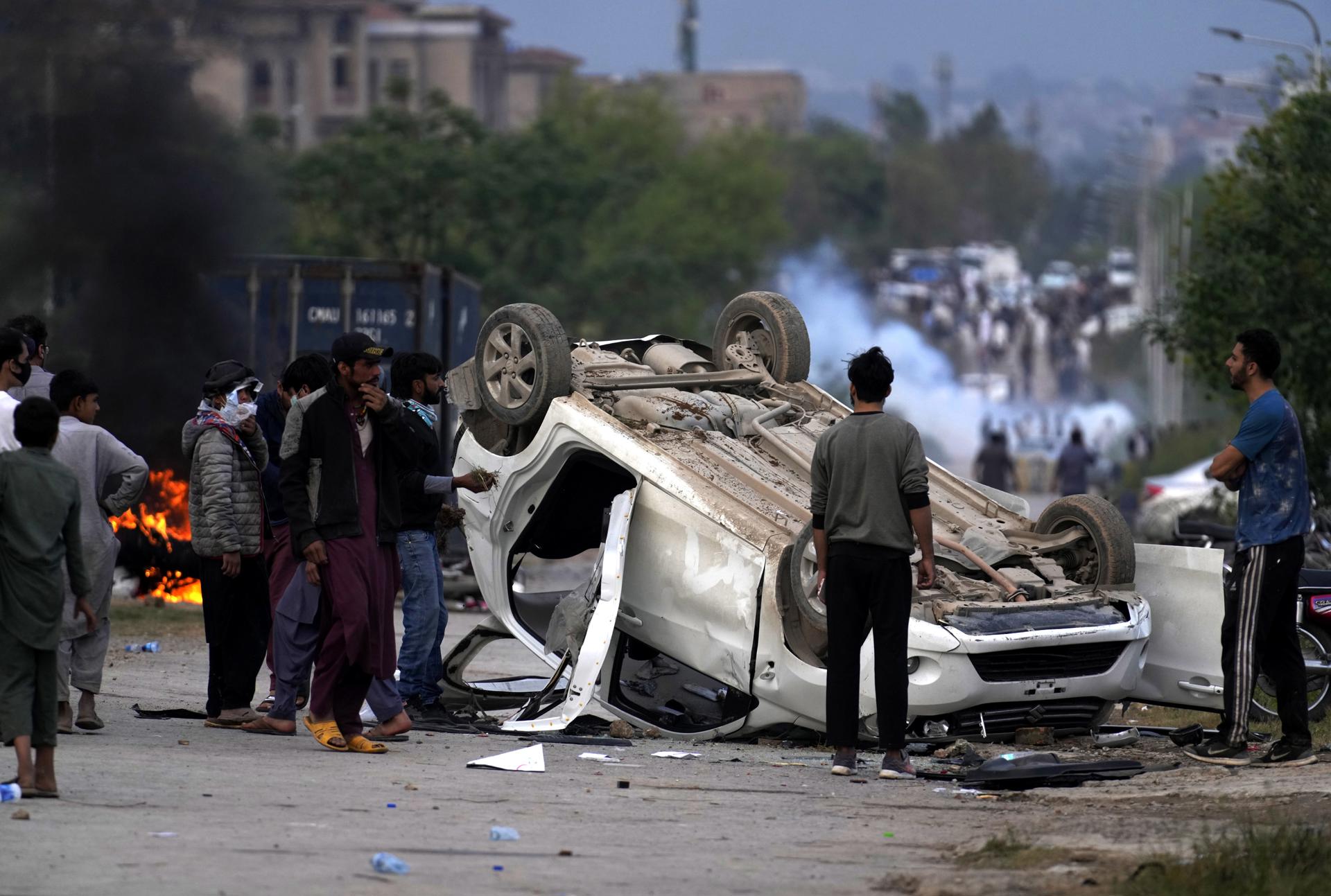 Supporters of opposition party Pakistan Tehrik-e-Insaf watch destroyed vehicles during clashes with police, as party leader Imran Khan is due to appear in a case, in Islamabad, Pakistan, 18 March 2023. EFE-EPA/SOHAIL SHAHZAD

