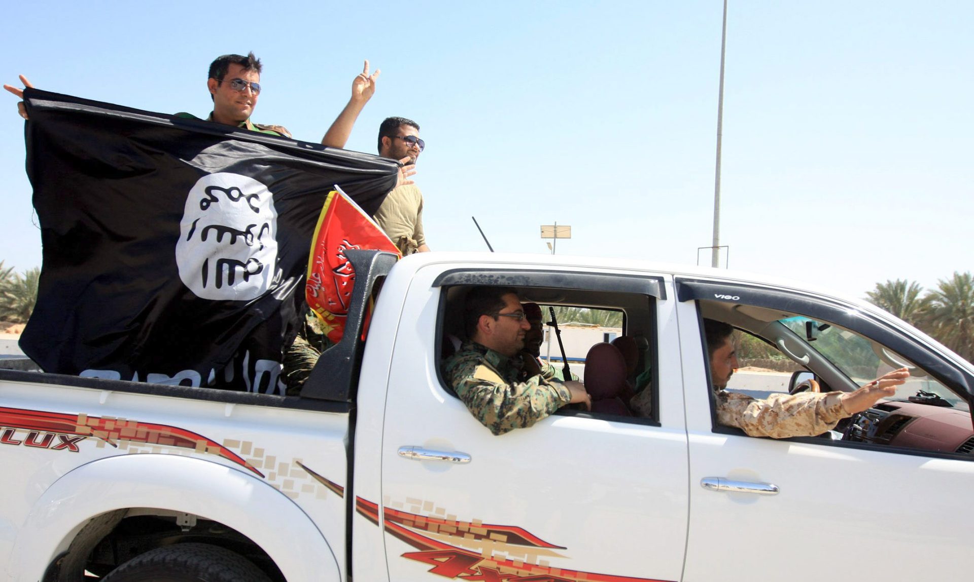 Un iraquí porta una bandera del EI.