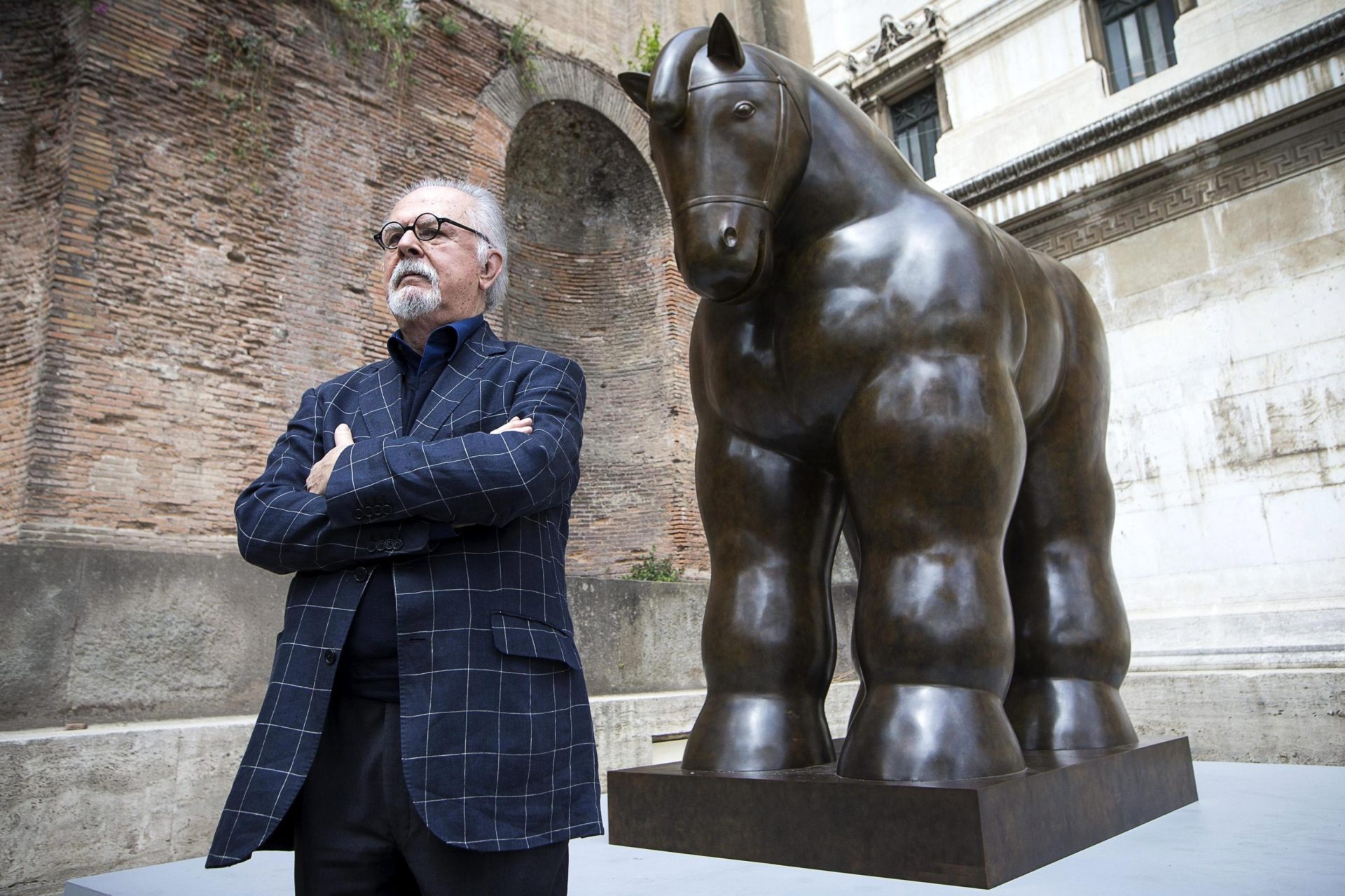 El artista colombiano Fernando Botero posa junto a una de sus esculturas, en una fotografía de archivo. EFE/Angelo Carconi