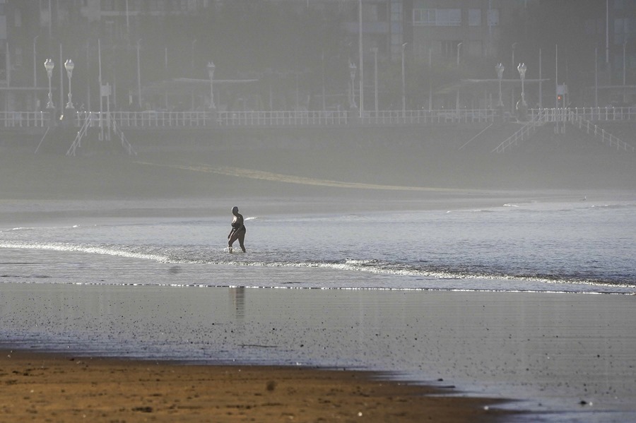 Una mujer se da un baño en la playa de San Lorenzo