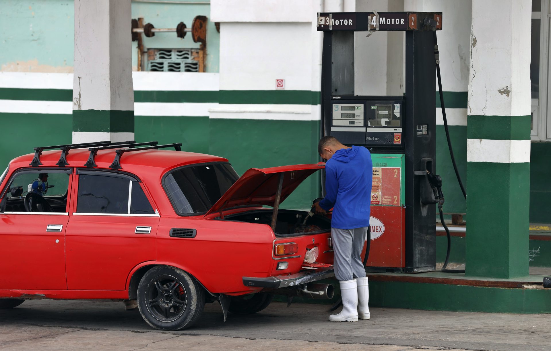 Fotografía que muestra una persona mientras pone gasolina en su vehículo hoy, en La Habana (Cuba). EFE/Ernesto Mastrascusa
