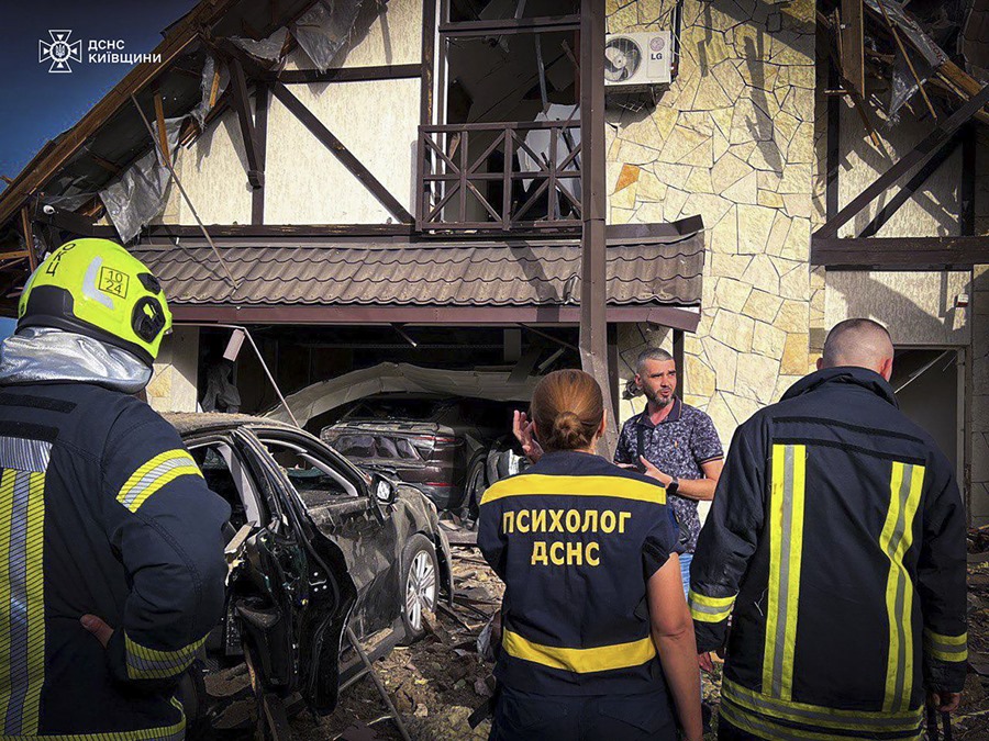 Imagen proporcionada por el Servicio Ucraniano de Emergencia que muestra a rescatistas en el lugar de un ataque con misiles contra una aldea cerca de Kiev