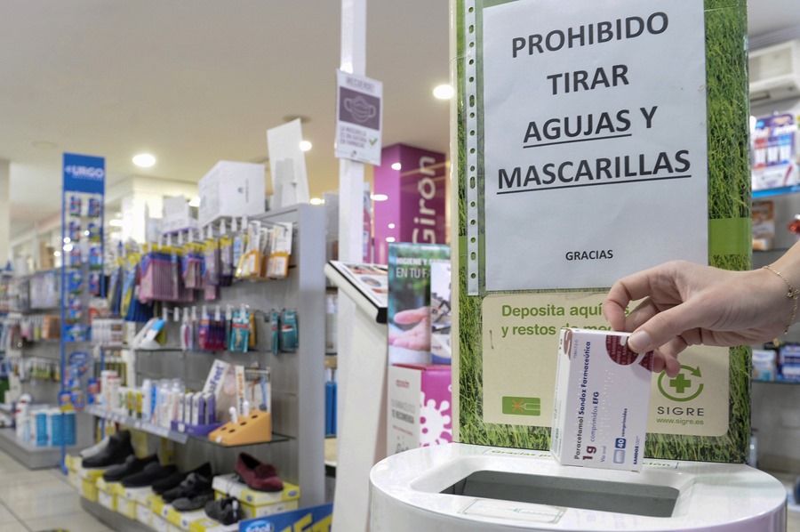 Una persona deposita una caja de un medicamento en una farmacia.